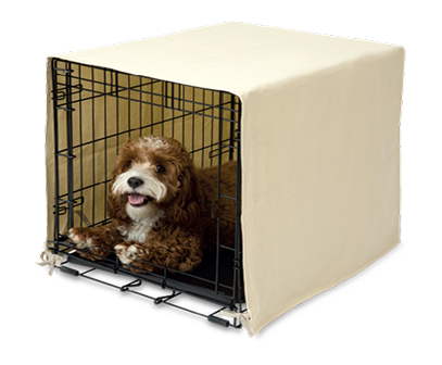Dog inside a metal crate with a beige cover on a white background